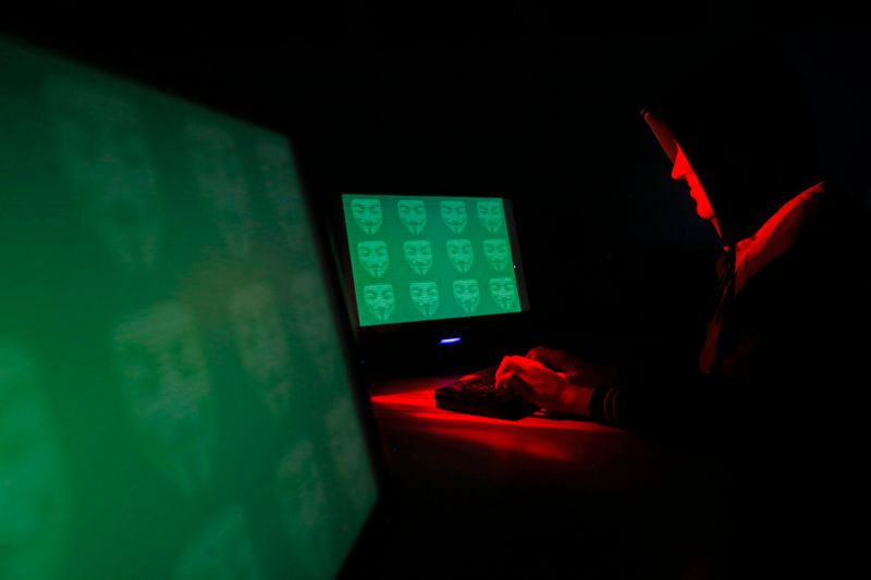 &copy; Reuters. Man poses in front of on a display showing the word &apos;cyber&apos; in binary code, in this picture illustration taken in Zenica