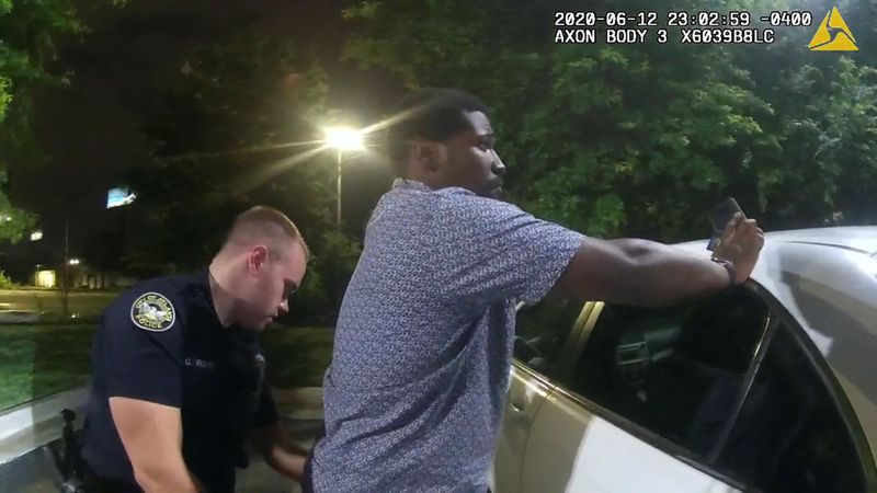 © Reuters. Former Atlanta Police Department officer Garrett Rolfe searches Rayshard Brooks in a Wendy's restaurant parking lot