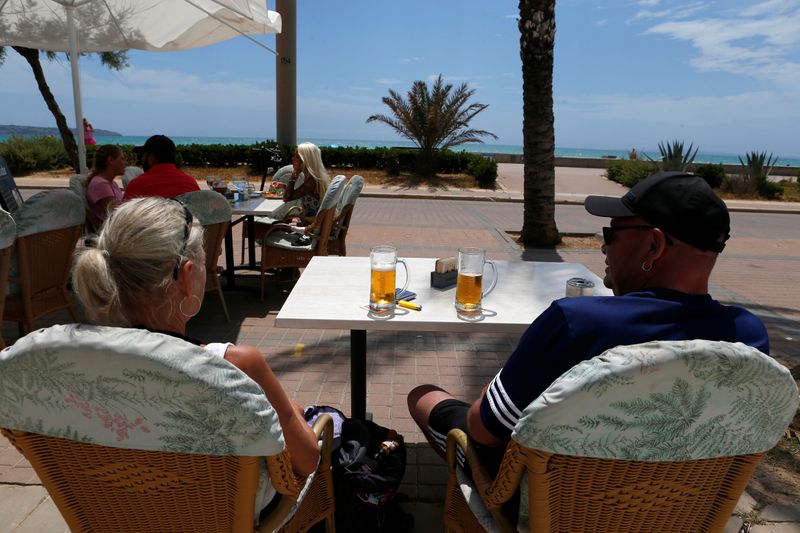&copy; Reuters. FOTO DE ARCHIVO: Una pareja sentada en la terraza de un bar frente a la playa de Palma de Mallorca