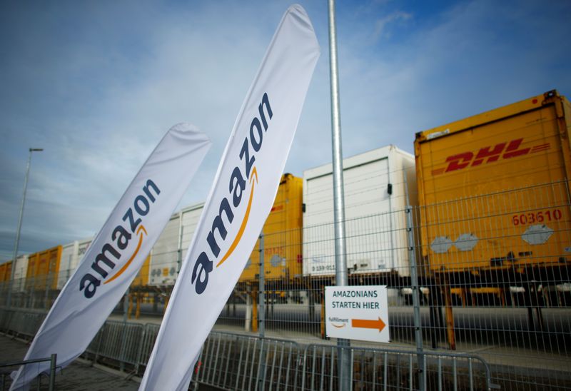 &copy; Reuters. Flags with the logo of Amazon and trailers of German postal and logistic Deutsche Post DHL Group are pictured outside the new Amazon logistic center in Dortmund