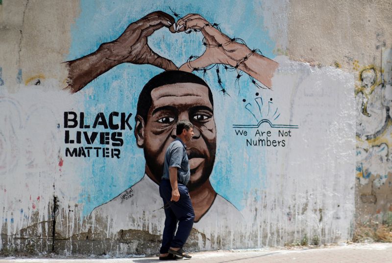 &copy; Reuters. A Palestinian man walks past a mural depicting George Floyd, in Gaza City
