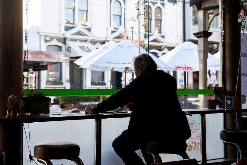 &copy; Reuters. Homem aguarda pedido em café da Nova Zelândia após restrições domésticas serem suspensas