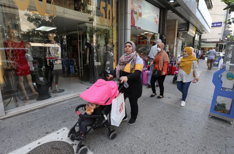 &copy; Reuters. FILE PHOTO: Women walk past open shops in Hamra street