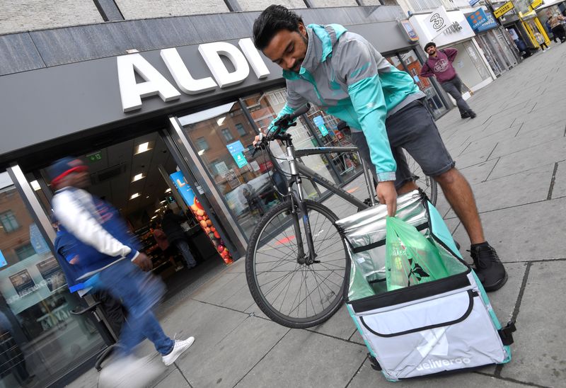 &copy; Reuters. Abdelaziz Abdou, a Deliveroo delivery rider, poses with a bag of Aldi groceries, London