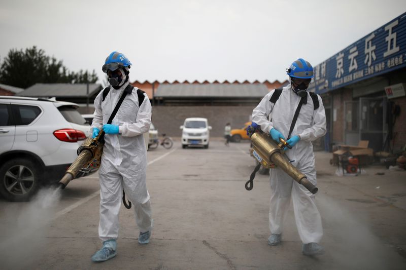 &copy; Reuters. Voluntarios del equipo de rescate Blue Sky desinfectan el mercado de Nangong en Pekín, China