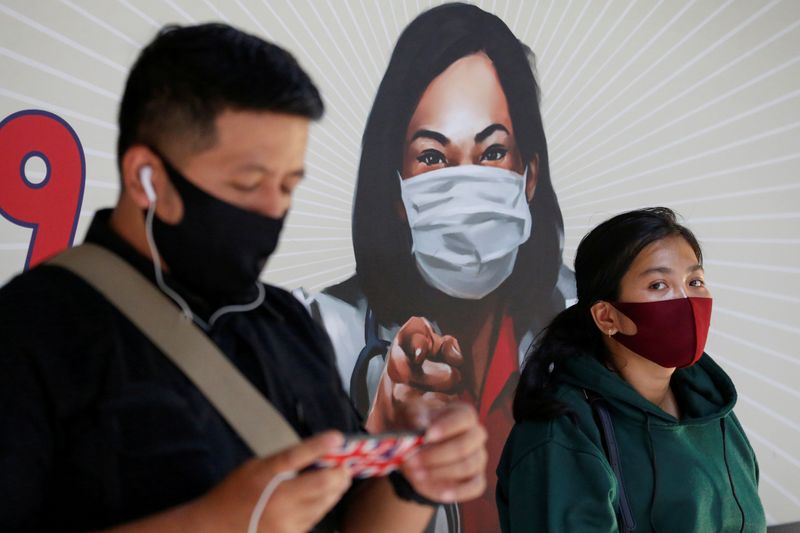 &copy; Reuters. FILE PHOTO: People are seen wearing protective face masks at a station in Jakarta, Indonesia