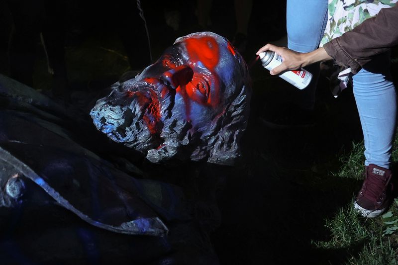 &copy; Reuters. Un manifestante rocía con pintura la estatua derribada del general confederado Albert Pike en Washington, EEUU