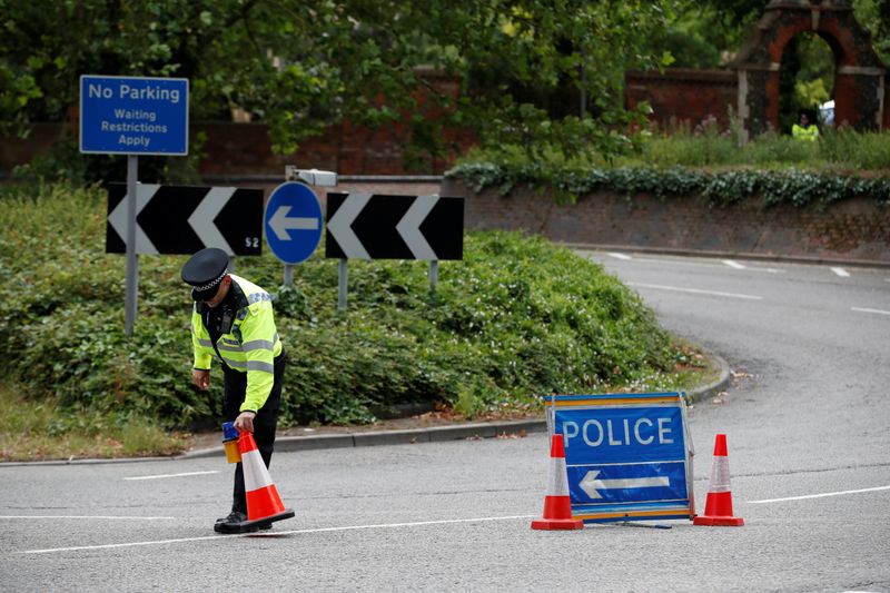 &copy; Reuters. A police officer puts a traffic cone on a street following multiple stabbings reported in Reading