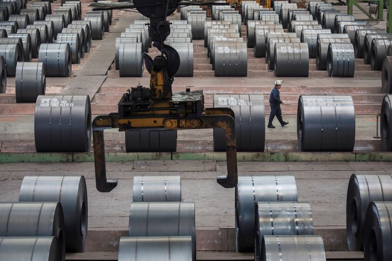 &copy; Reuters. Worker walks past steel rolls at the Chongqing Iron and Steel plant in Changshou