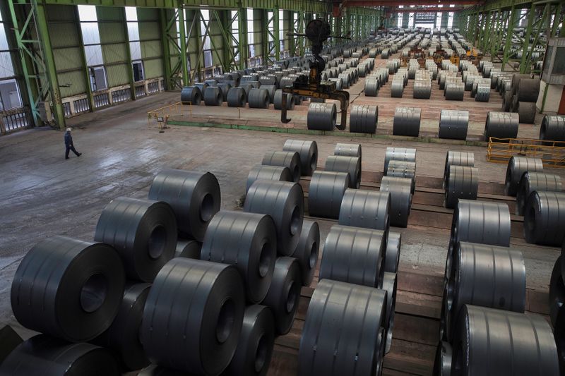 &copy; Reuters. FILE PHOTO: Worker walks by steel rolls at the Chongqing Iron and Steel plant in Changshou