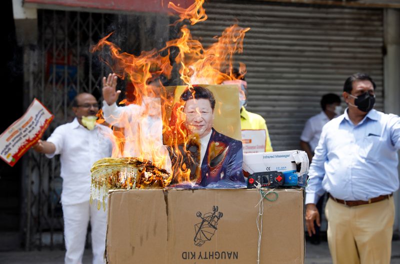 &copy; Reuters. Manifestantes ateiam fogo a produtos chineses a foto do presidente da China, Xi Jinping, em Nova Délhi