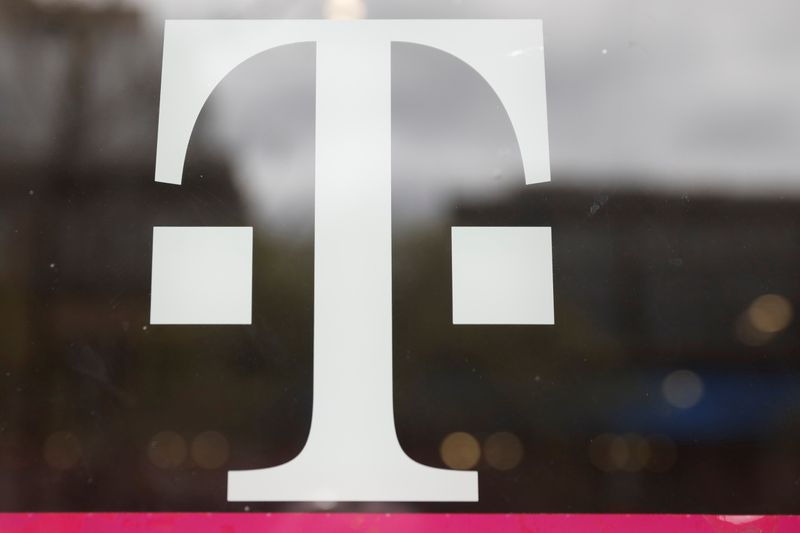 &copy; Reuters. A T-Mobile logo is seen on the storefront door of a store in Manhattan
