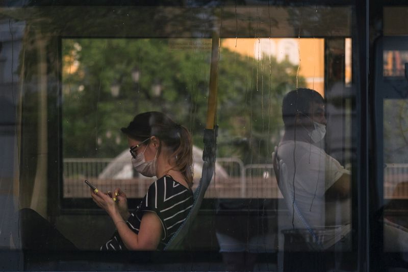 &copy; Reuters. Пассажиры в защитных масках в автобусе в Москве