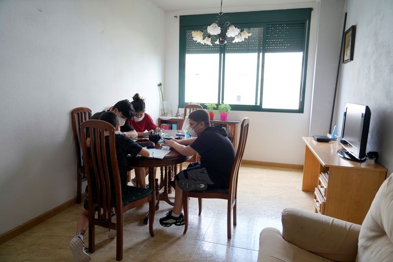 &copy; Reuters. Guillermo Merino helps his friend Matias Dieguez to do his homework amid the coronavirus disease (COVID-19) outbreak in Madrid