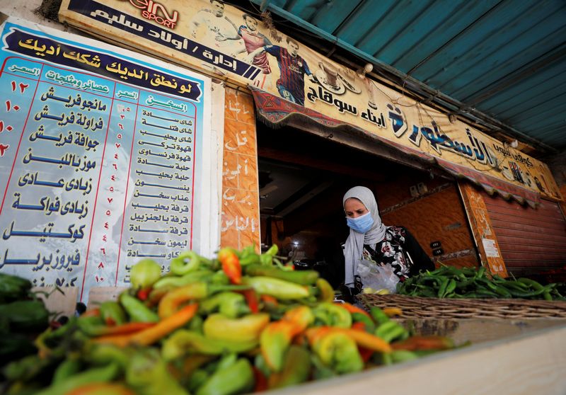 © Reuters. FOTO DE ARCHIVO: Una mujer compra verduras en una cafetería que se ha convertido en una verdulería de El Cairo.
