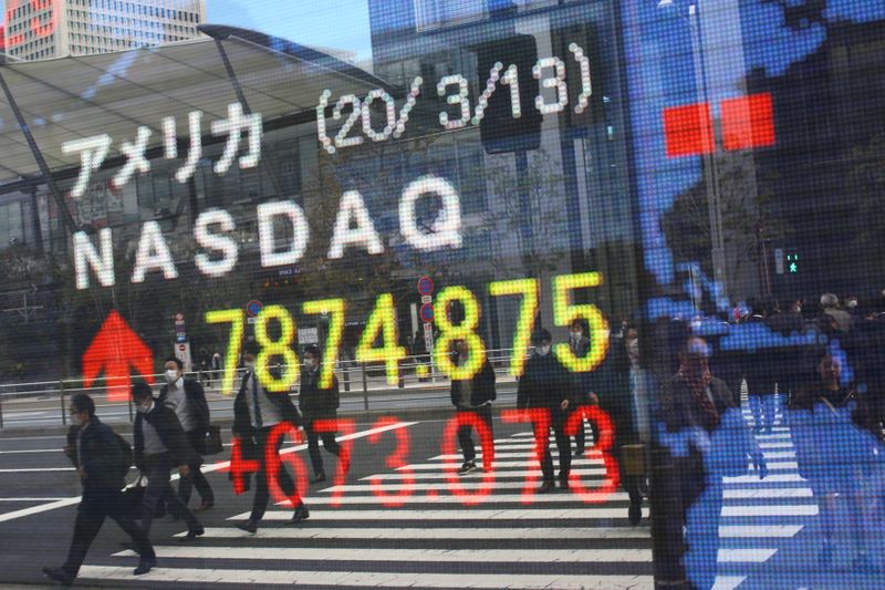 &copy; Reuters. FILE PHOTO: People wear protective face masks as they are reflected in a stock quotation board outside a brokerage in Tokyo