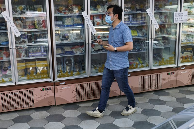 &copy; Reuters. FILE PHOTO: Man walks past sealed freezers containing seafood products at a supermarket in Beijing