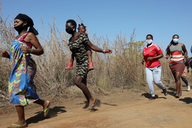 &copy; Reuters. Mulheres e crianças caminham para receberm ajuda alimentar em meio à pandemia de Covid-19 em Pretoria, na África do Sul