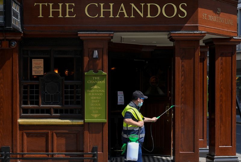 &copy; Reuters. Homem joga desinfetante no exterior de pub em Londres