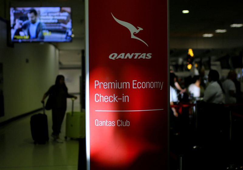 &copy; Reuters. A passenger walks with their luggage as they approach a Qantas Airways check-in counter at Sydney International Airport