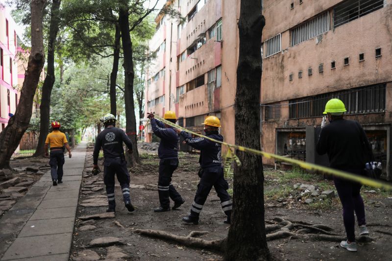 &copy; Reuters. Members of Civil Protection check an apartment building damaged by an earthquake that struck southern Mexico on Tuesday, in Mexico City