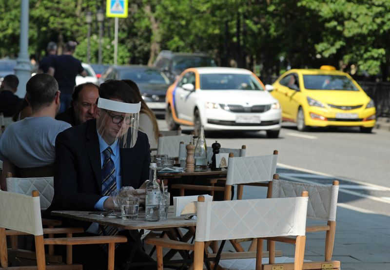 &copy; Reuters. Мужчина в защитном щитке в московском кафе