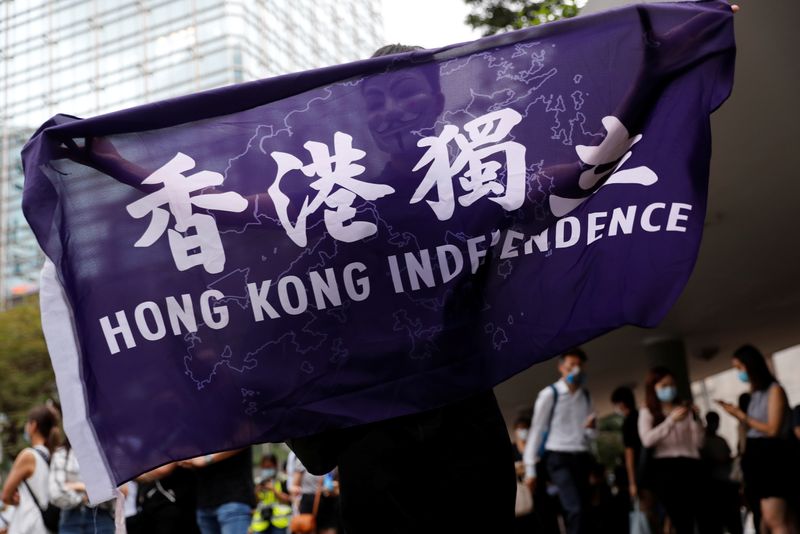 © Reuters. A pro-democracy demonstrator holds a flag supporting Hong Kong Independence during a protest to mark the first anniversary of a mass rally against the now-withdrawn extradition bill, in Hong Kong