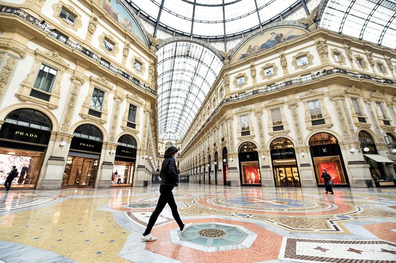 &copy; Reuters. FILE PHOTO: A woman wearing a protective face mask walks in Galleria Vittorio Emanuele II after a decree orders for the whole of Italy to be on lockdown in an unprecedented clampdown aimed at beating the coronavirus, in Milan
