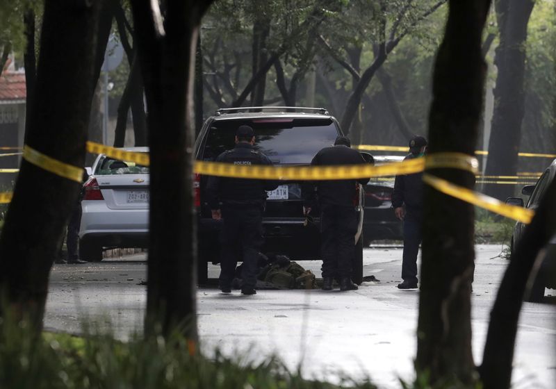 © Reuters. Police officers are seen near a vehicle after a shooting in Mexico City