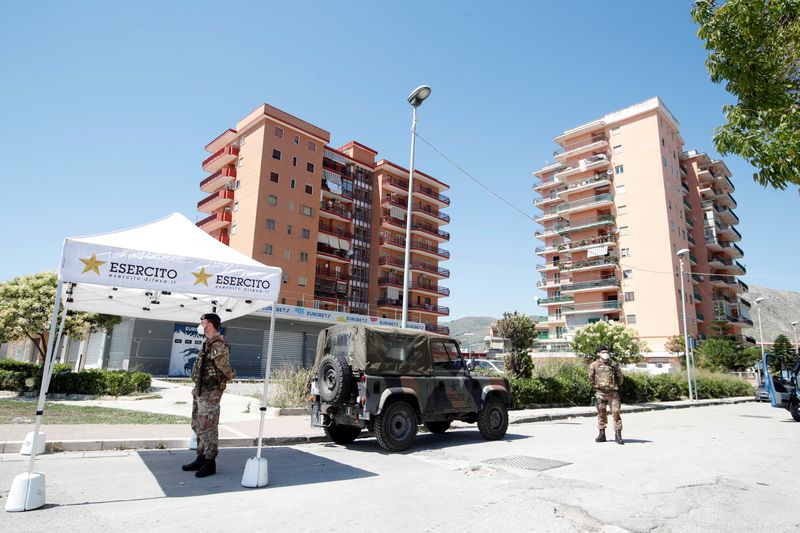 &copy; Reuters. Soldados italianos em frente a conjunto de apartamentos ocupado por imigrantes onde foi identificado novo surto de Covid-19 em Mondragone