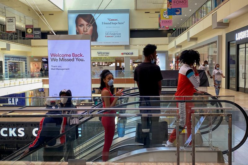 &copy; Reuters. Customers ride an escalator at The Galleria shopping mall after it opened during the coronavirus disease (COVID-19) outbreak in Houston