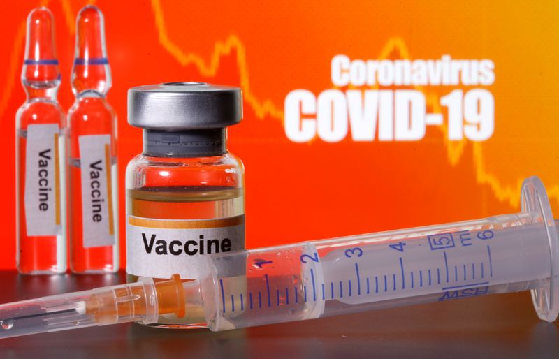 &copy; Reuters. Small bottles labeled with &quot;Vaccine&quot; stickers stand near a medical syringe in front of displayed &quot;Coronavirus COVID-19&quot; words in this illustration