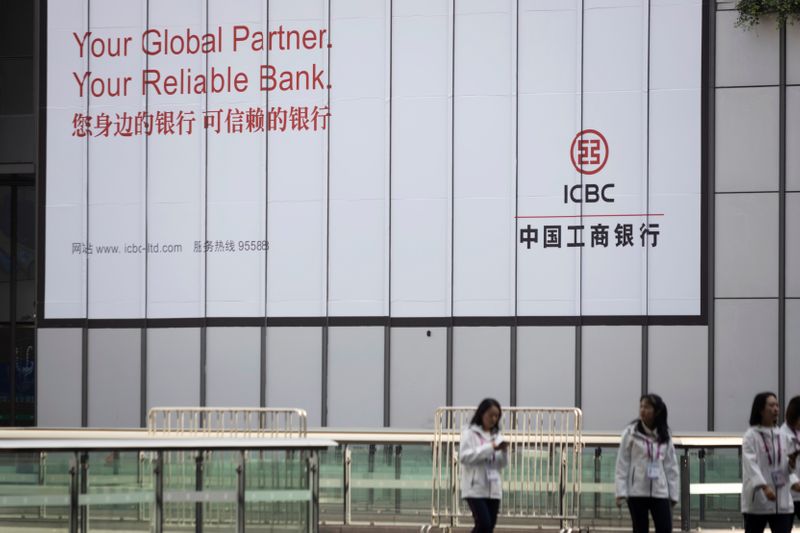 &copy; Reuters. FILE PHOTO:  People walk past a sign of the Industrial and ICBC at the venue for the second China International Import Expo (CIIE) in Shanghai