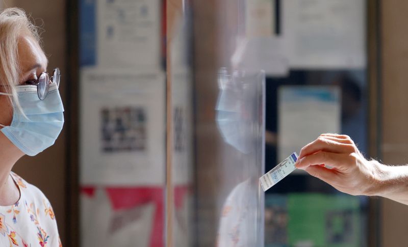 &copy; Reuters. Un votante muestra su identificación en una mesa electoral durante la segunda vuelta de las elecciones municipales, en París