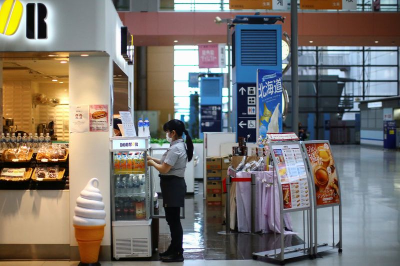 &copy; Reuters. A vendor, wearing protective mask following an outbreak of the coronavirus disease (COVID-19), works at the almost empty Kansai International Airport in Osaka