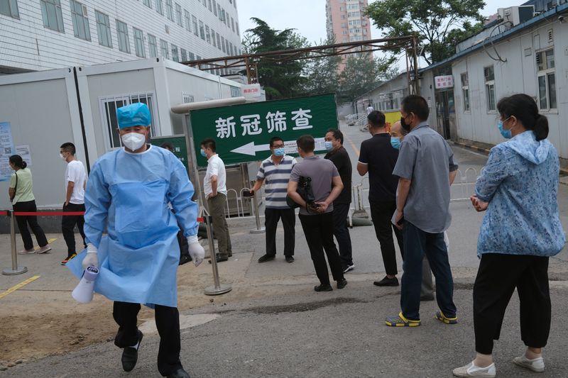 © Reuters. People wearing face masks line up to enter a site for nucleic acid tests at a hospital, following the outbreak of the coronavirus disease (COVID-19), in Beijing