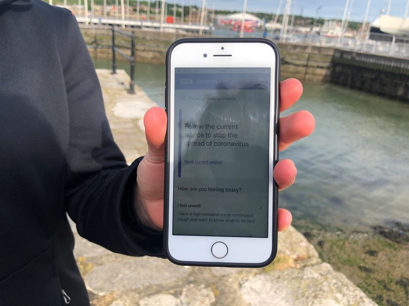 &copy; Reuters. FILE PHOTO:  UK National Health Service employee Anni Adams shows a smartphone displaying the new NHS app to trace contacts with people potentially infected with the coronavirus disease (COVID-19) being trialled on Isle of Wight