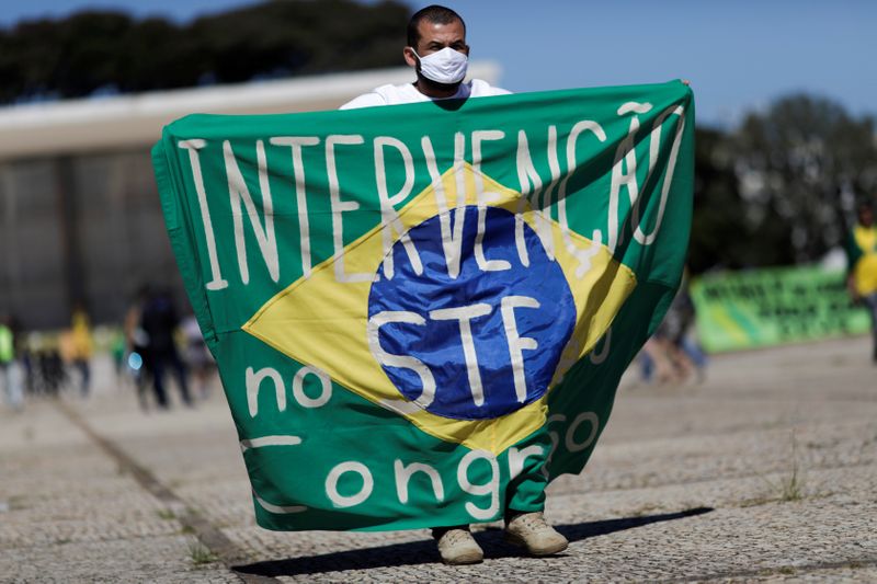 &copy; Reuters. Manifestante com bandeira que defende intervenção no STF e no Congresso durante ato em Brasília