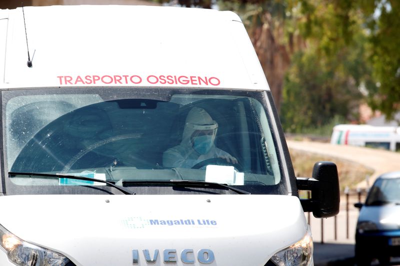 &copy; Reuters. Profissional de saúde com trajes de proteção dentro de van em Mondragone, na Itália