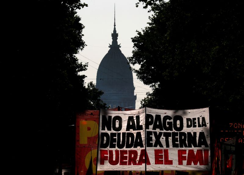 &copy; Reuters. FILE PHOTO: Demonstrators hold a placard that reads &quot;no to foreign debt payment, IMF out&quot; as they march towards Casa Rosada Presidential Palace during a protest in opposition to the visit of an IMF technical team to Buenos Aires