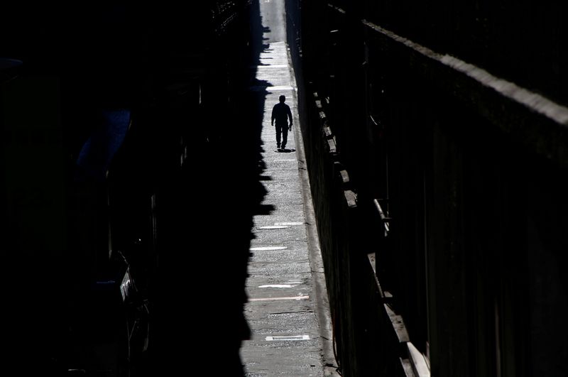 &copy; Reuters. FILE PHOTO: A man walks in a small road between two commercial buildings at a business district in Tokyo