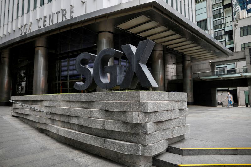 &copy; Reuters. FILE PHOTO: A man wearing a protective face mask walks past the Singapore Exchange
