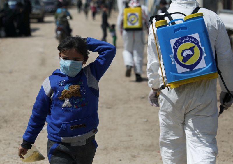 &copy; Reuters. FILE PHOTO: An internally displaced Syrian girl wears a face mask as members of the Syrian Civil defence sanitize the Bab Al-Nour internally displaced persons camp, to prevent the spread of coronavirus disease (COVID-19) in Azaz