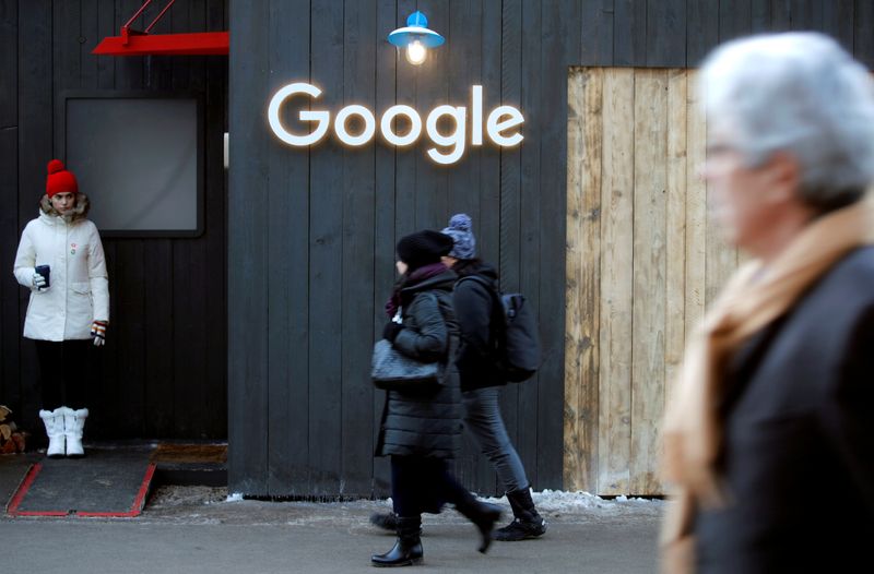 &copy; Reuters. FILE PHOTO: People walk past the logo of Google in Davos
