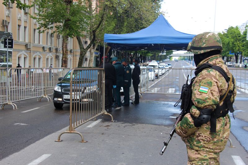 &copy; Reuters. Сотрудники правоохранительных органов проверяют документы водителей а КПП в Ташкенте