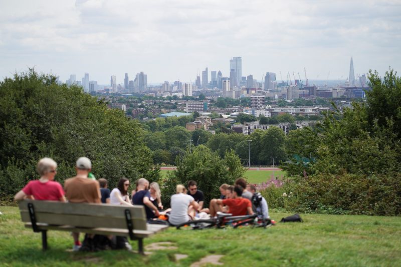 &copy; Reuters. People relax on Parliament Hill during warm weather in London