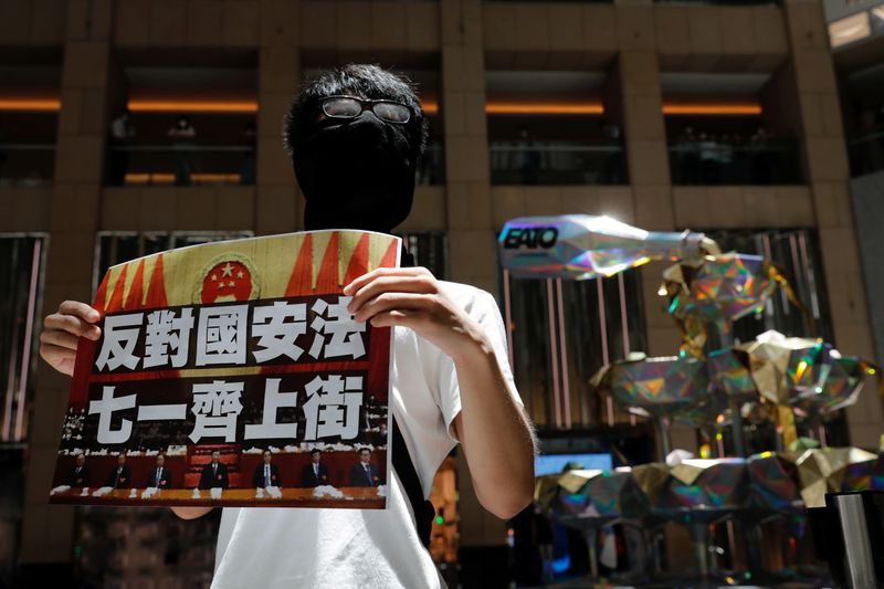 &copy; Reuters. Un manifestante pro-democracia sostiene un cartel que dice &quot;Contra la ley de seguridad nacional. Marcha el 1 de julio&quot; en una protesta después de que el parlamento chino aprobara una ley de seguridad nacional para Hong Kong, en Hong Kong, China