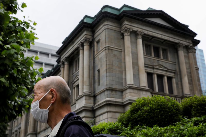 &copy; Reuters. FILE PHOTO: A man wearing a protective mask stands in front of the headquarters of Bank of Japan amid the coronavirus disease (COVID-19) outbreak in Tokyo