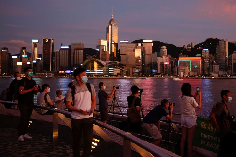 &copy; Reuters. People enjoy the sunset view with a skyline of buildings during a meeting on national security legislation, in Hong Kong