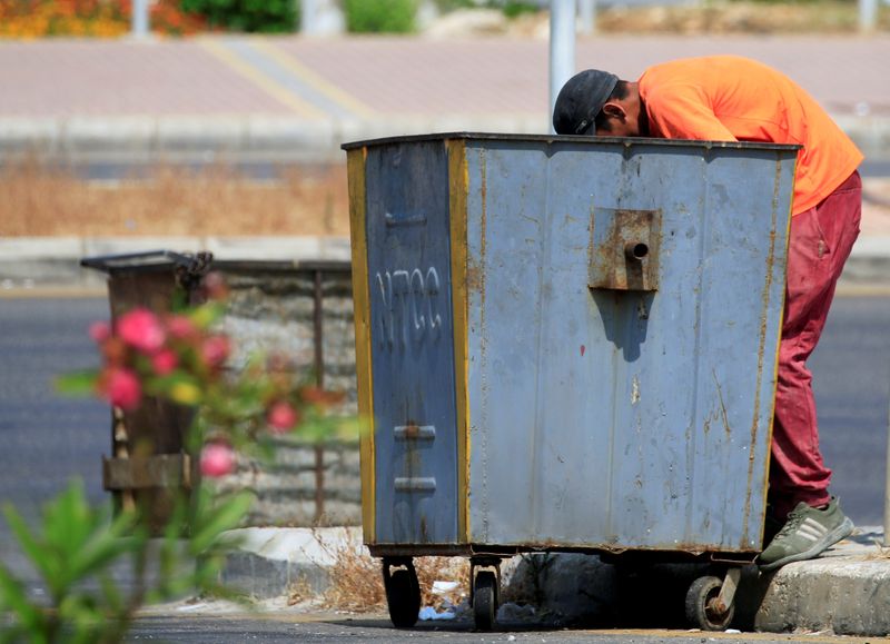 © Reuters. A man searches through a garbage bin in Sidon